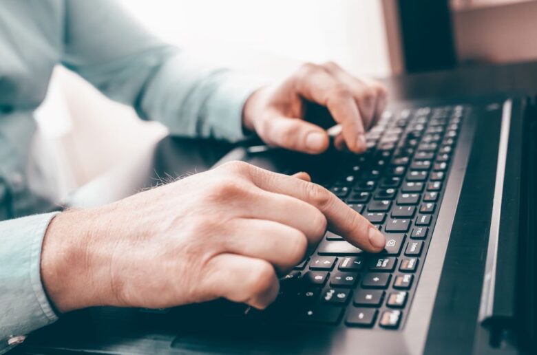 man typing on laptop